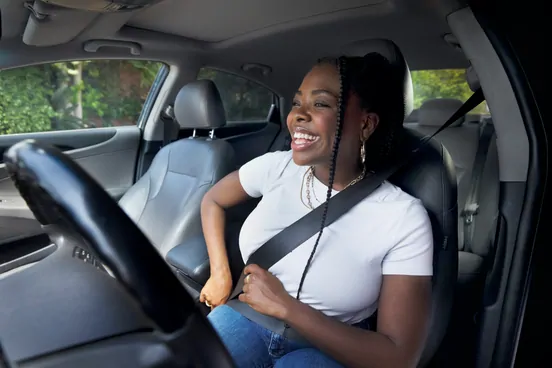 Confident Xryde driver smiling beside their car