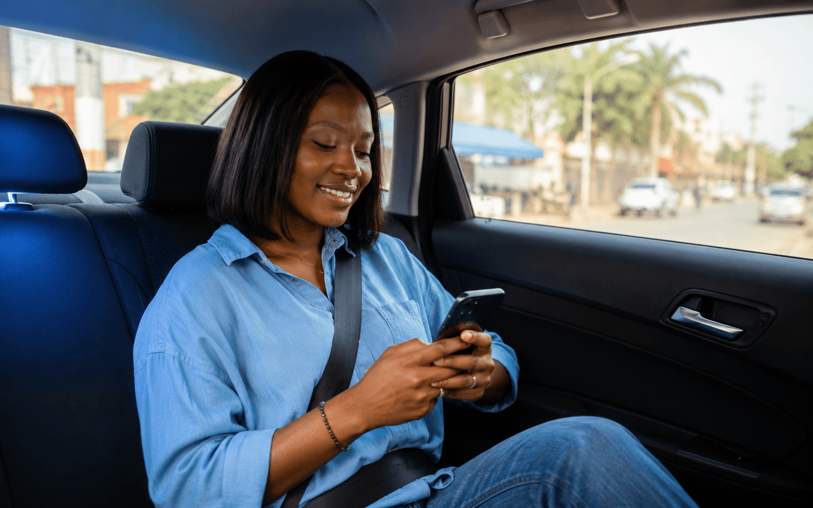 Rider relaxing in the back seat, checking the Xryde app